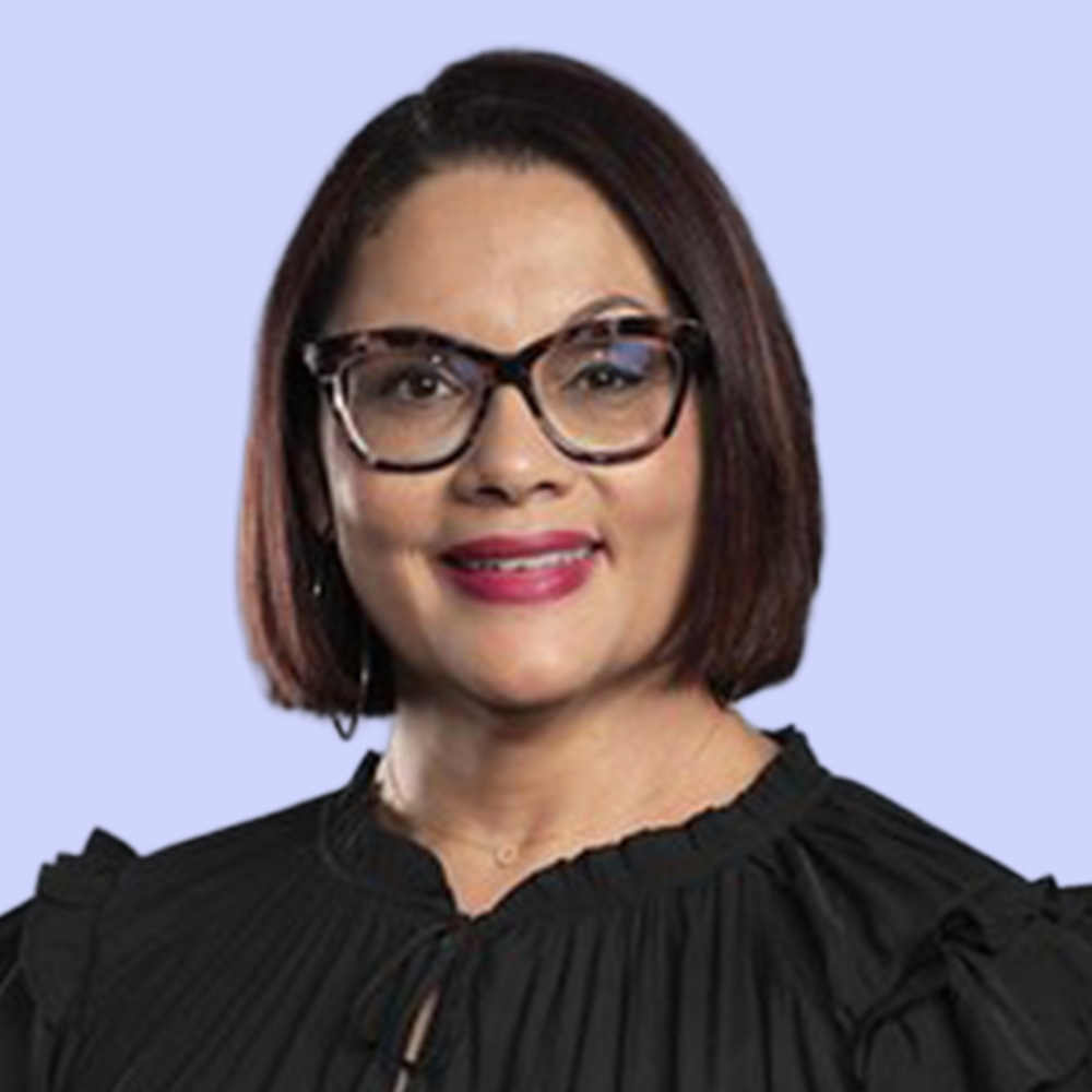 Marisele Esperance smiles fora photo with a light purple background